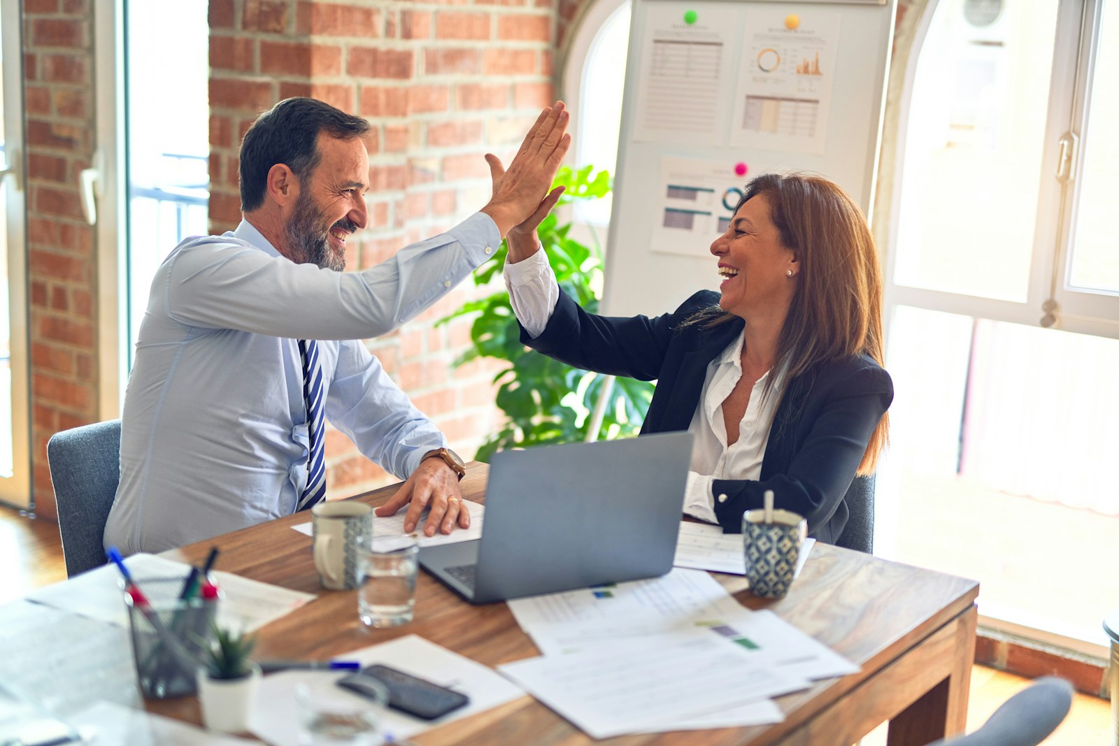 Business colleagues celebrating a successful collaboration in an office