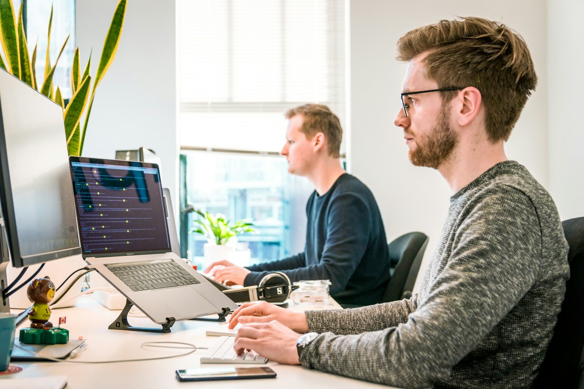 Technology professionals working at computers in a bright office